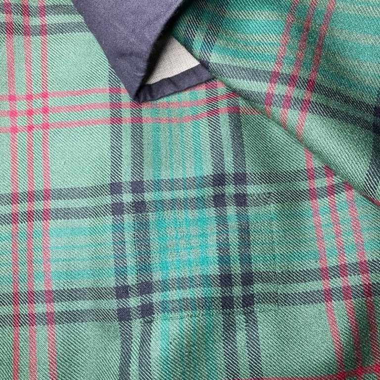 Close-up of invisible mending repair on damaged repair on damaged tartan kilt fabric - Glasgow kilt restoration service